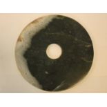 A Chinese jade disk with pierced circular central section. 31x31cm