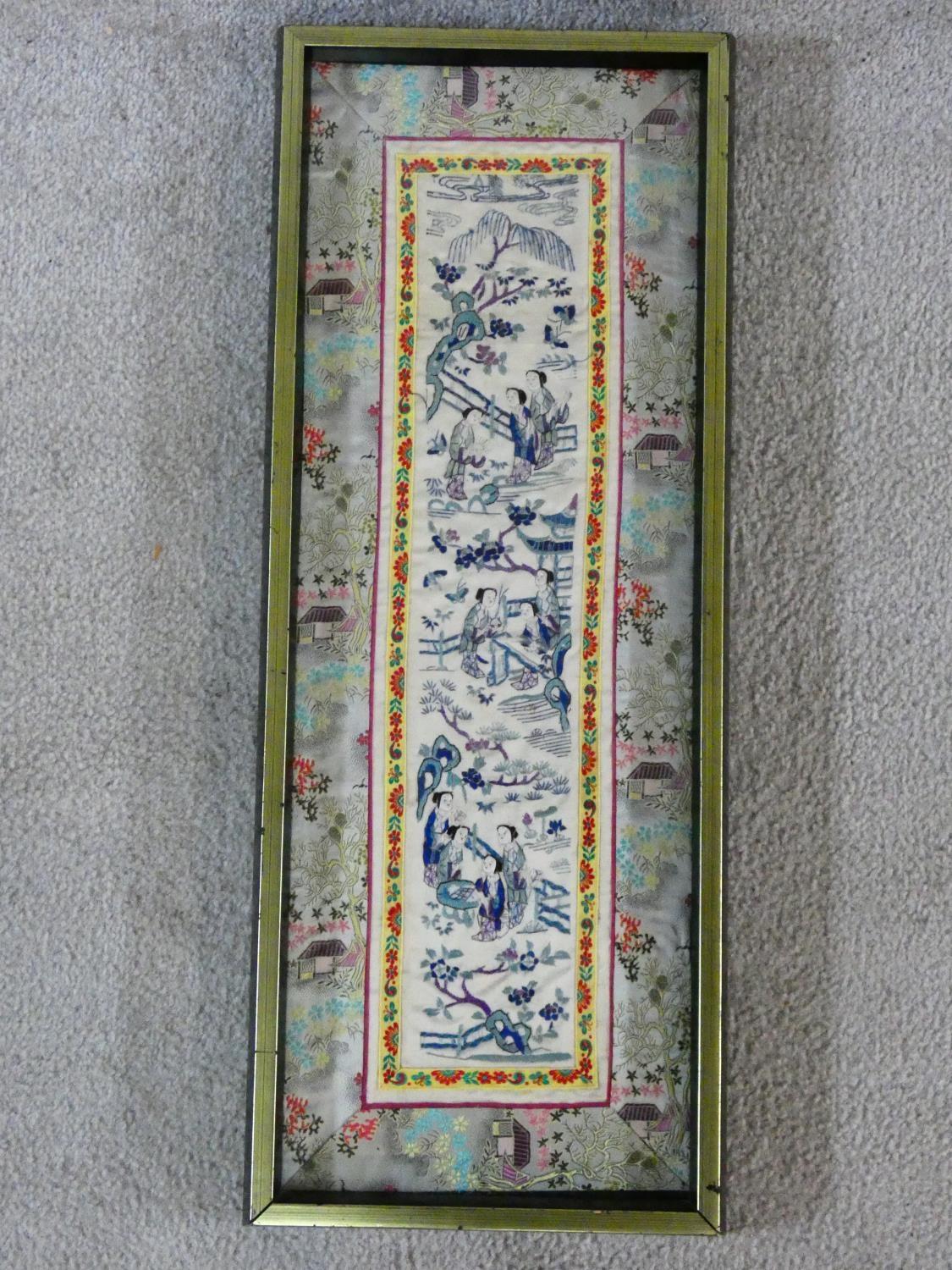 A 19th century Chinese framed and glazed silk panel, figures in a landscape within a floral woven