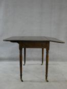A 19th century mahogany Pembroke table with frieze drawer opposing dummy drawer raised on turned