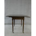 A 19th century mahogany Pembroke table with frieze drawer opposing dummy drawer raised on turned