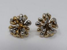 A pair of 9ct yellow and white gold and diamond stylised floral stud earrings. Each earring is set