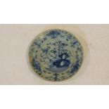 An antique blue and white floral design glazed hand painted ceramic plate. It has a bright yellow