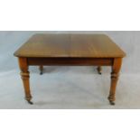 A 19th century mahogany extending dining table on turned tapering supports with extra leaf and