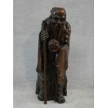 A Ming dynasty carved Chinese root wood sculpture of an immortal, an elderly man holding a staff and