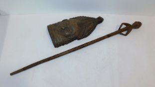 An African carved wooden tribal mask from Sierra Leone and a tribal wooden staff with a carved