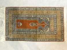 An Eastern prayer mat with floral design on burgundy ground contained within geometric multi