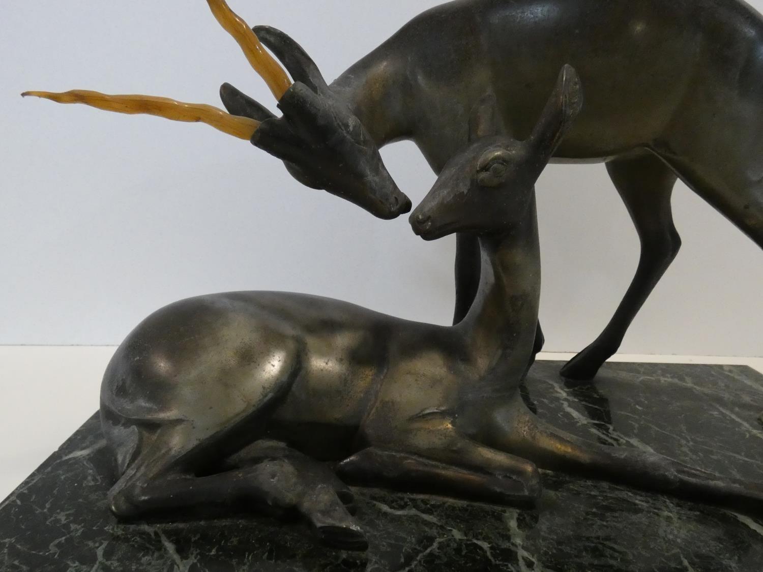 A pair of spelter Art Deco male and female gazelles mounted on a black and white veined marble base. - Image 4 of 7
