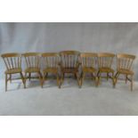 A set of seven spindle back kitchen dining chairs with rail backs on turned stretchered supports,