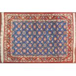 A Veramin Mina Khani style rug with repeating scrolling vine and floral decoration on a deep