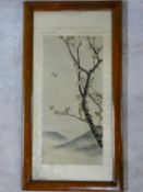 An early 20th century framed and glazed Japanese silk embroidery, a bird in flight with blossom on