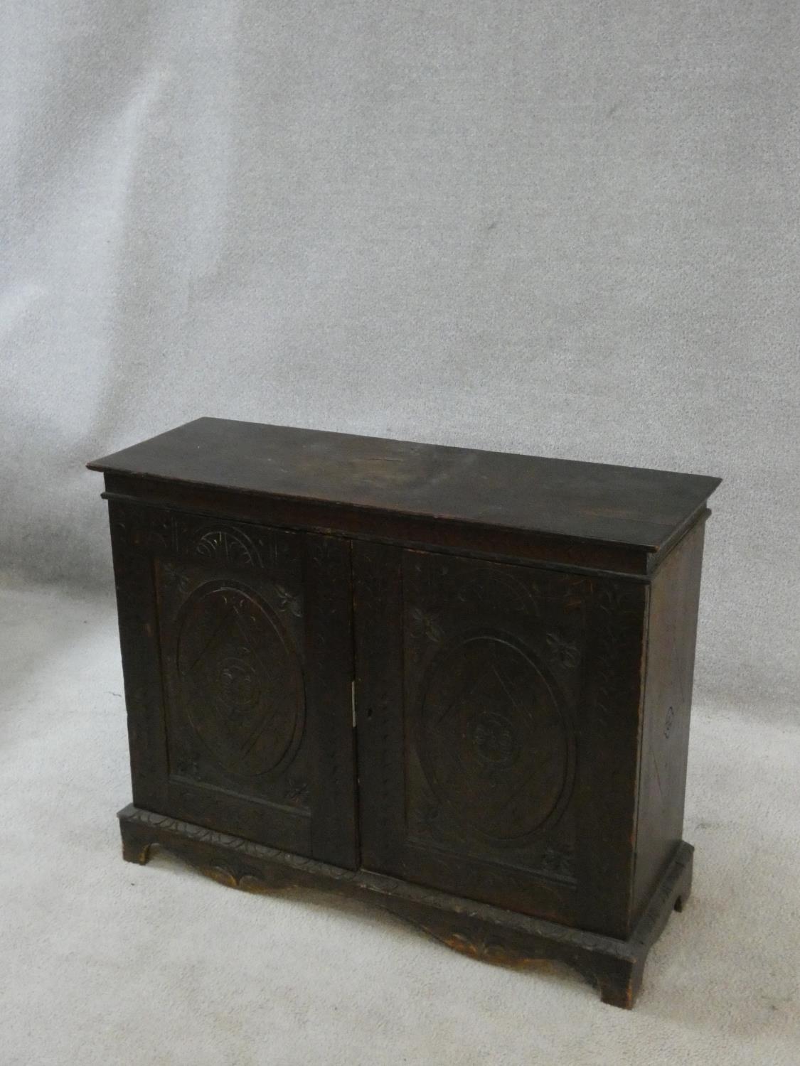 An antique country oak hall cupboard with a pair of carved panel doors on bracket feet. H.64 W.82 - Image 6 of 7