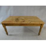 A Victorian pine kitchen dining table with planked top and end drawer on turned tapering supports.
