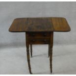 A Regency mahogany Pembroke work table fitted with two frieze drawers opposing dummy drawers on