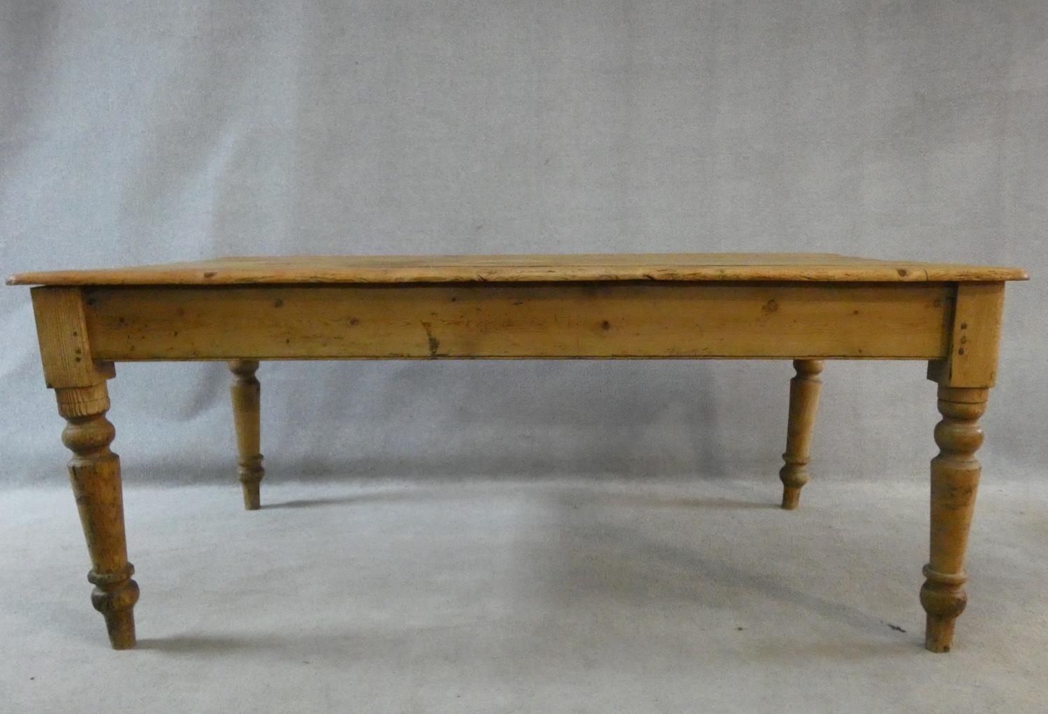 A Victorian pine kitchen dining table with planked top and end drawer on turned tapering supports. - Image 2 of 16