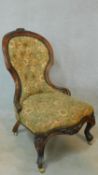 A Victorian carved walnut framed nursing chair in floral tapestry upholstery on cabriole supports.