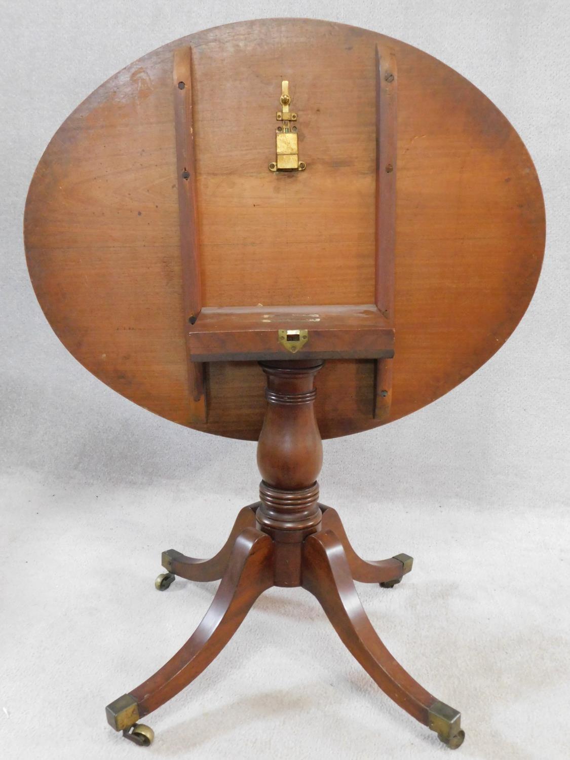 A 19th century mahogany tilt top tea table on swept quadruped supports terminating in brass cap - Image 5 of 5