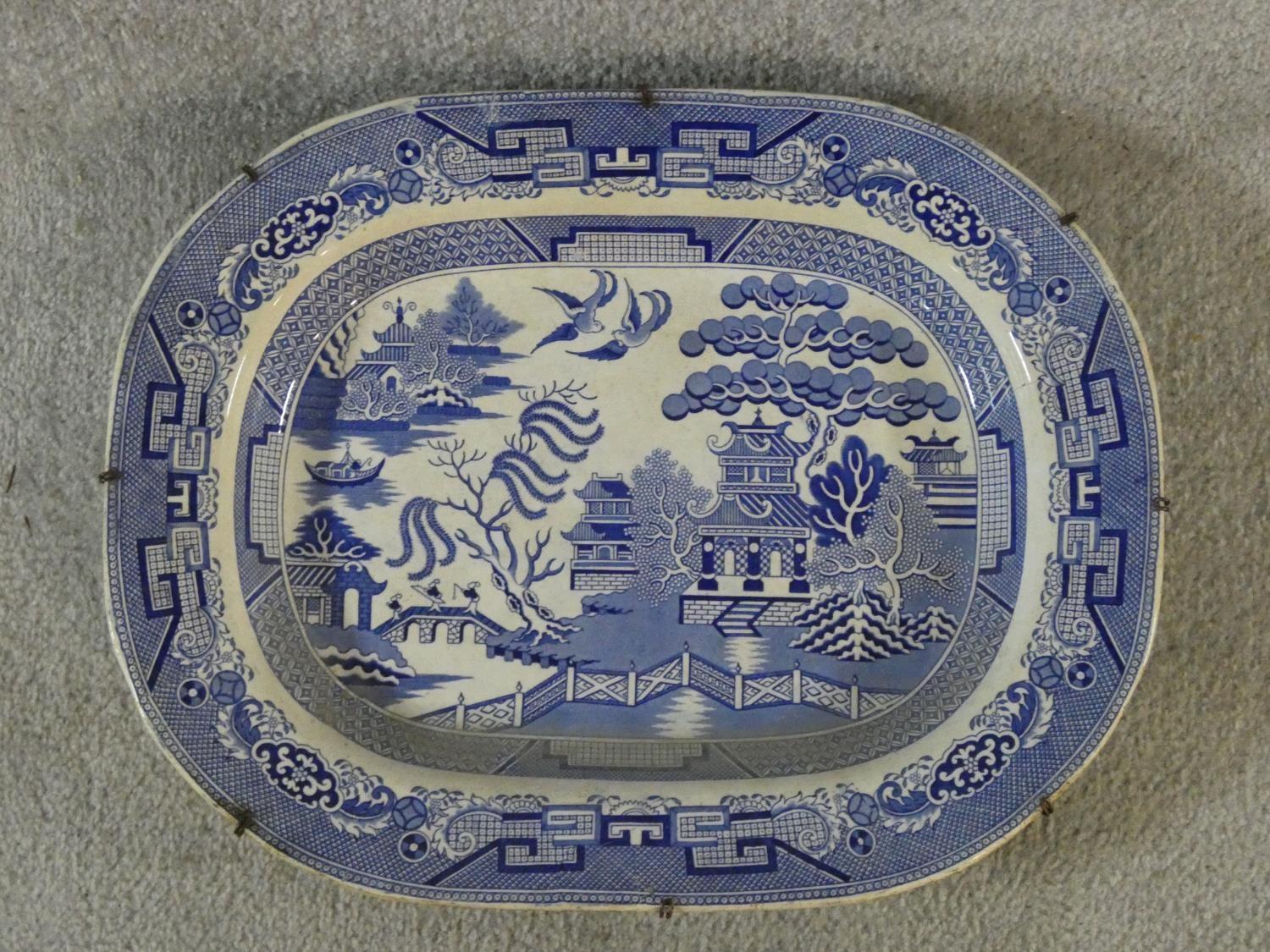 A large antique Staffordshire stoneware blue and white willow pattern transferware design meat