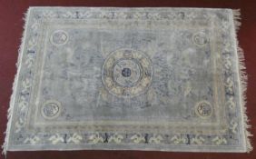 A Chinese carpet with central floral medallion on pale ground contained by spandrels decorated