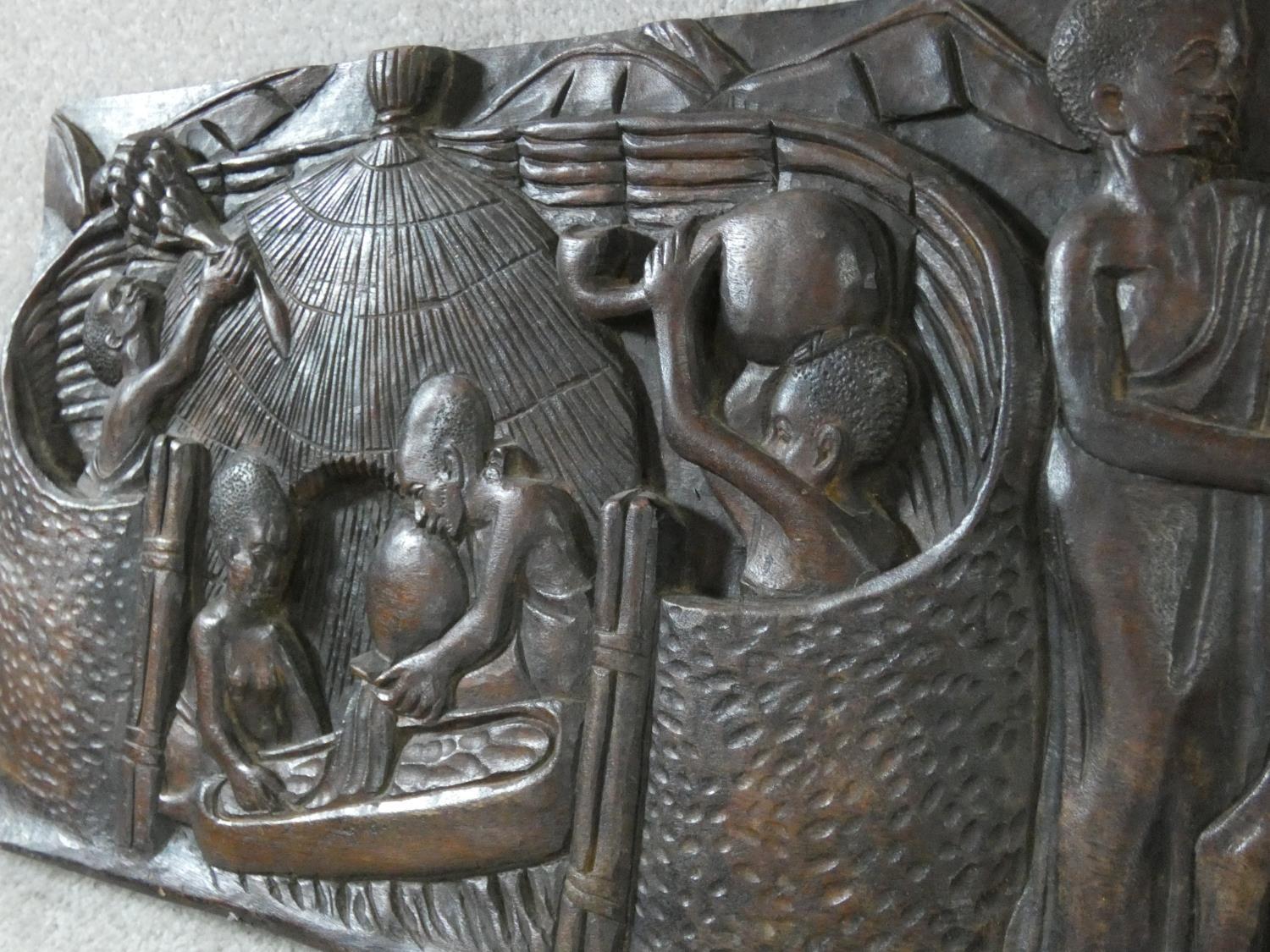 A carved African hardwood panel, farmers and cattle in a village setting, indistinctly signed to the - Image 5 of 7