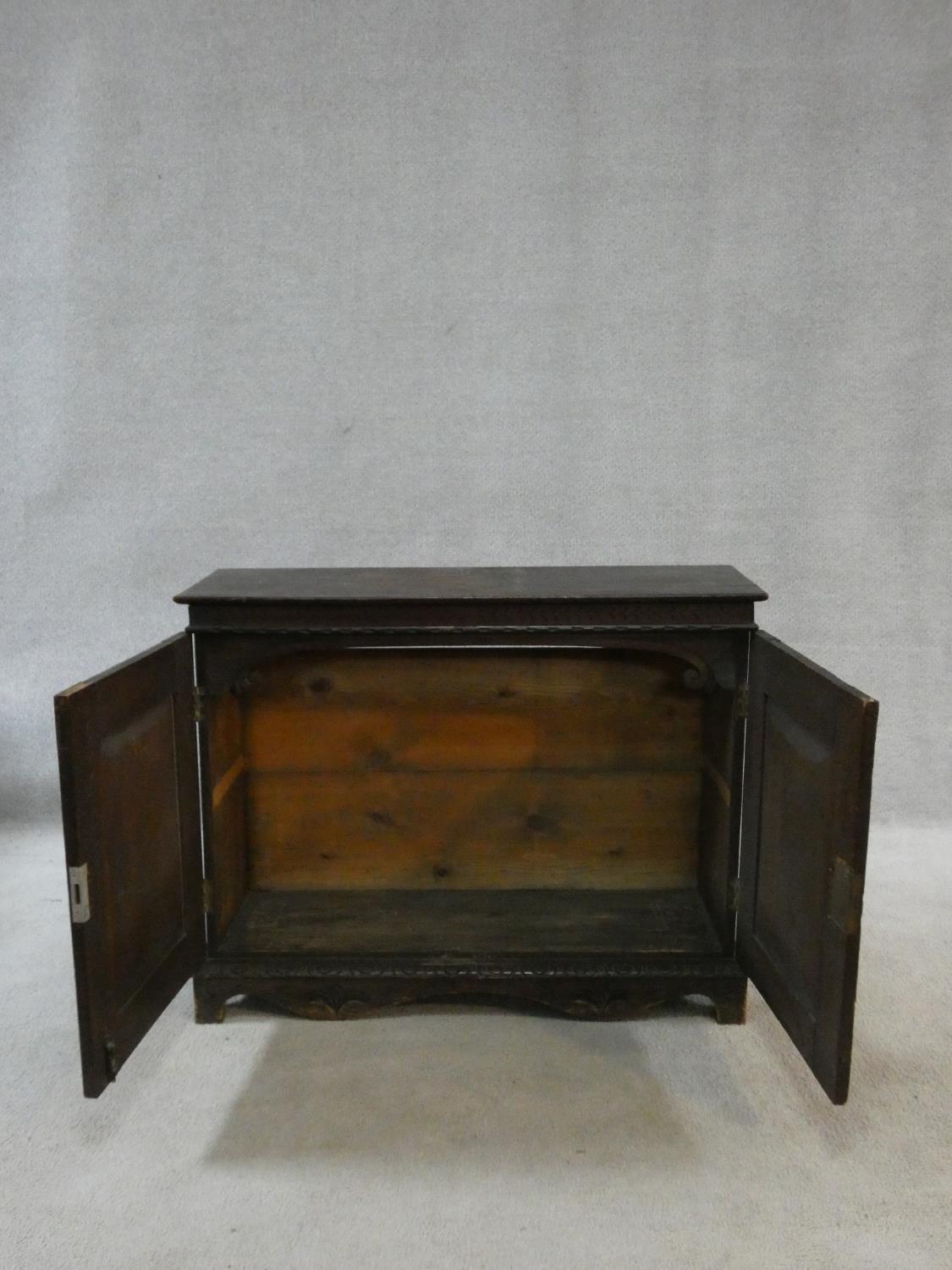 An antique country oak hall cupboard with a pair of carved panel doors on bracket feet. H.64 W.82 - Image 4 of 7