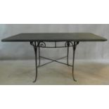 A circular wrought iron conservatory table on swept supports with heavy slate top. H.74 W.150 D.94cm