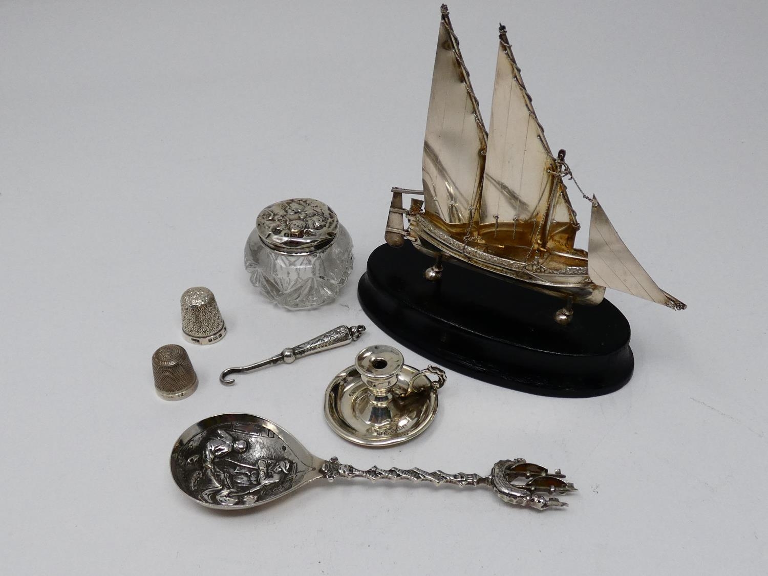 A collection of silver and white metal items. Including a Maltese articulated sailing ship on an