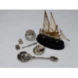 A collection of silver and white metal items. Including a Maltese articulated sailing ship on an