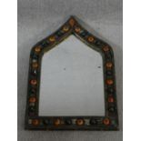 An Indian brass and metal mirror with moulded orange and black bead studded detailing and repousse