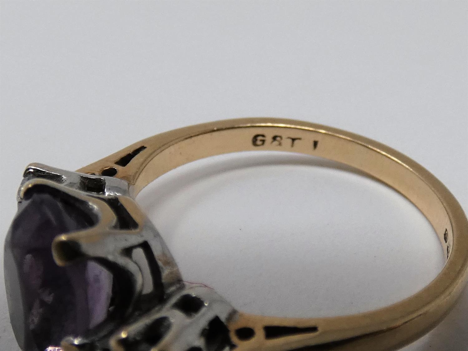 A 9ct yellow gold and white metal three stone ring, set with purple and white paste stones. Shank - Image 4 of 6