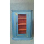 A 19th century distressed painted corner cupboard with glazed door enclosing shelves. H.125 W.87 D.