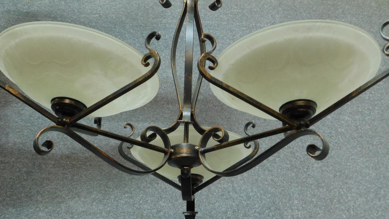 A wrought metal framed three branch ceiling chandelier with floral decorated opaque shades 50x75cm - Image 2 of 5