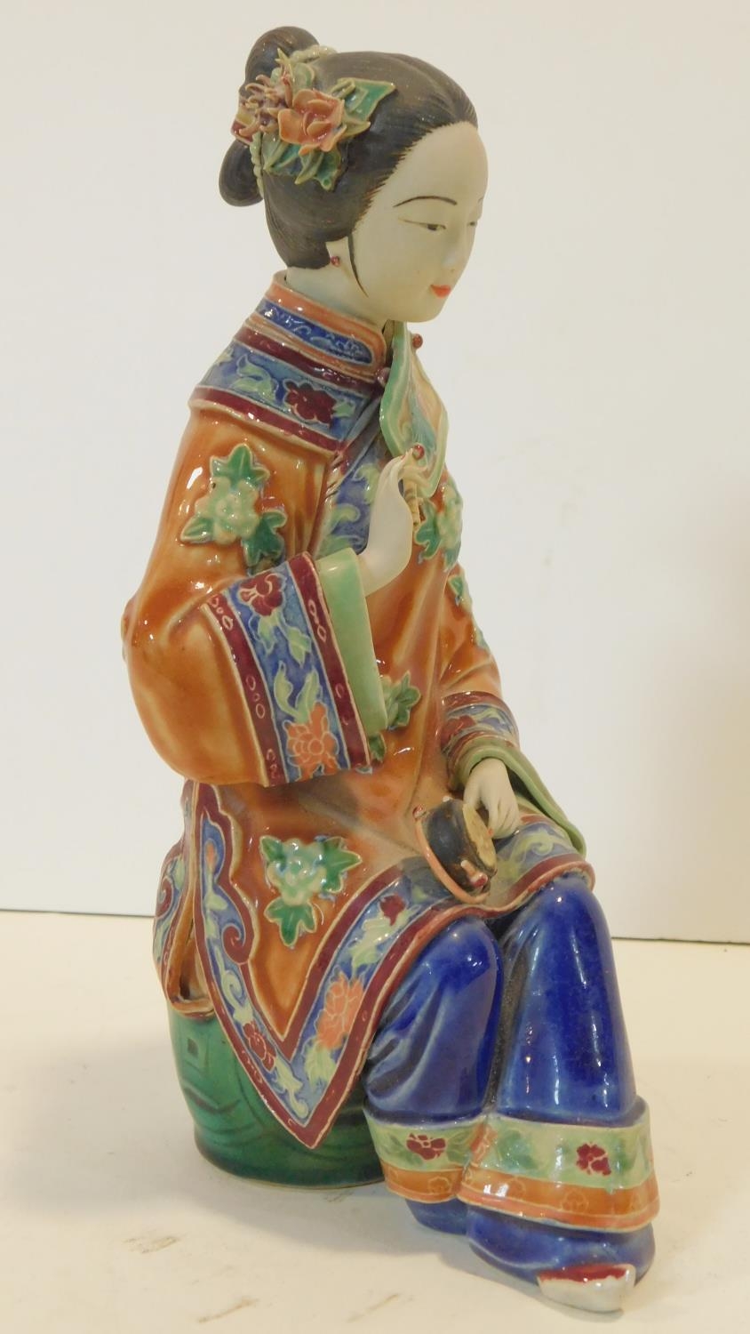 A Japanese ceramic figure of a lady sitting on a garden seat in polychrome hand painted decoration - Image 2 of 8