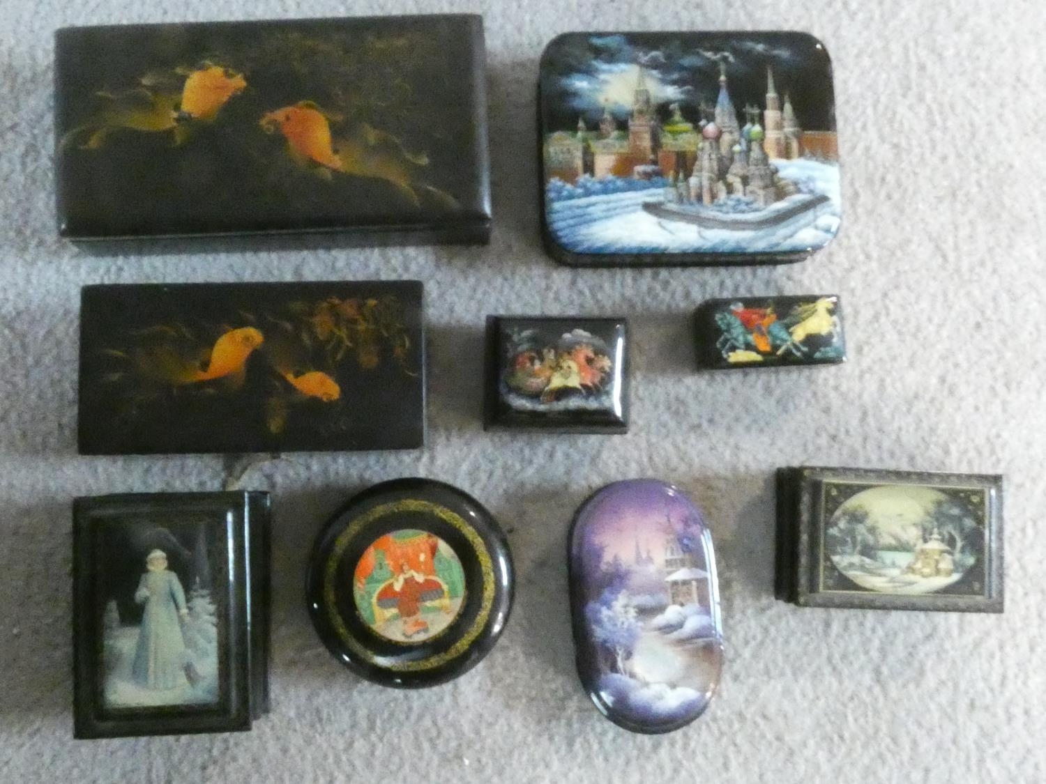 A collection of nine black lacquered trinket and pill boxes, Russian, Japanese and Indian each