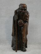 A Ming dynasty carved Chinese root wood sculpture of an immortal, an elderly man holding a staff and