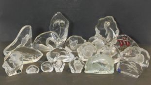 An extensive collection of glass paper weights each with various carved animals, boats and flowers.