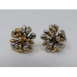 A pair of 9ct yellow and white gold and diamond stylised floral stud earrings. Each earring is set