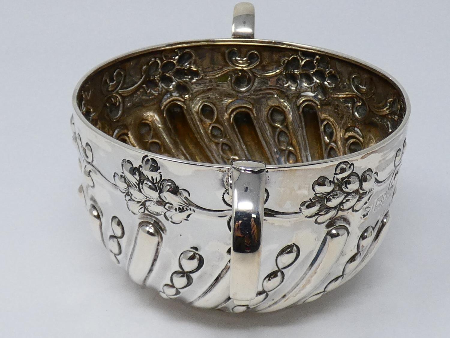 A two handled Victorian repousse design silver porriger with floral design and scrolling handles. - Image 6 of 6