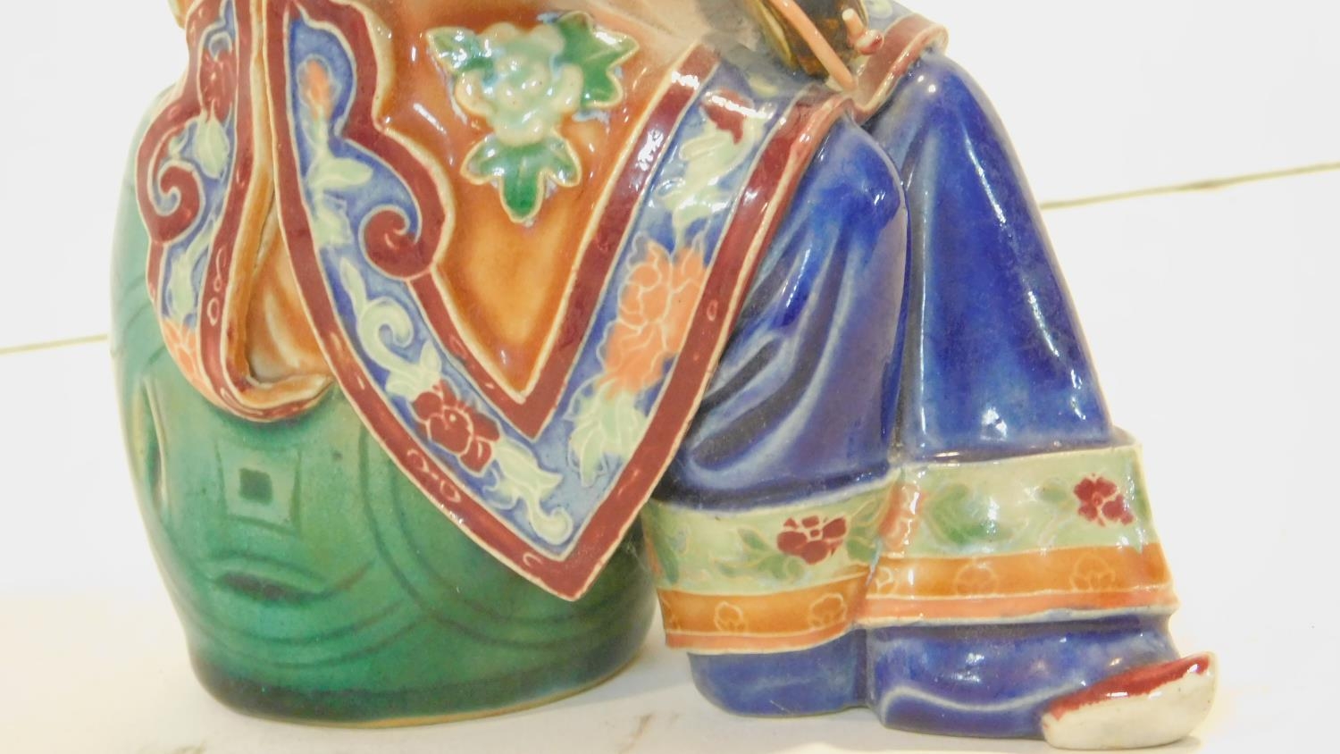 A Japanese ceramic figure of a lady sitting on a garden seat in polychrome hand painted decoration - Image 5 of 8