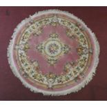 A woollen Chinese style carpet with floral decoration on a blush ground. D.208cm