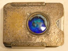 A Liberty Tudric style hammered pewter playing card case with iridescent blue enamel central roundel