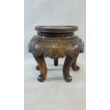 An antique Chinese hardwood urn stand with all-over floral carving on five scrolling cabriole