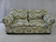 A two seater sofa in sage and pale blue floral upholstery. H.76xW.175xL.100cm