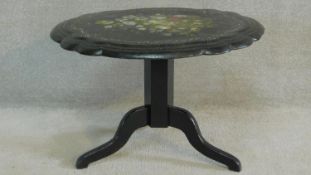 A Victorian papier mache tilt top occasional table hand painted with a floral spray and inlaid