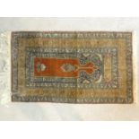 An Eastern prayer mat with floral design on burgundy ground contained within geometric multi