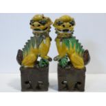 A pair of Chinese ceramic sancai glazed Dogs of Fo in green, ochre and brown glaze. H.35cm (damage