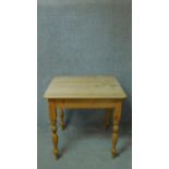 A Victorian kitchen table with scrubbed pine top on turned tapering supports. H.79 W.81 D.71cm