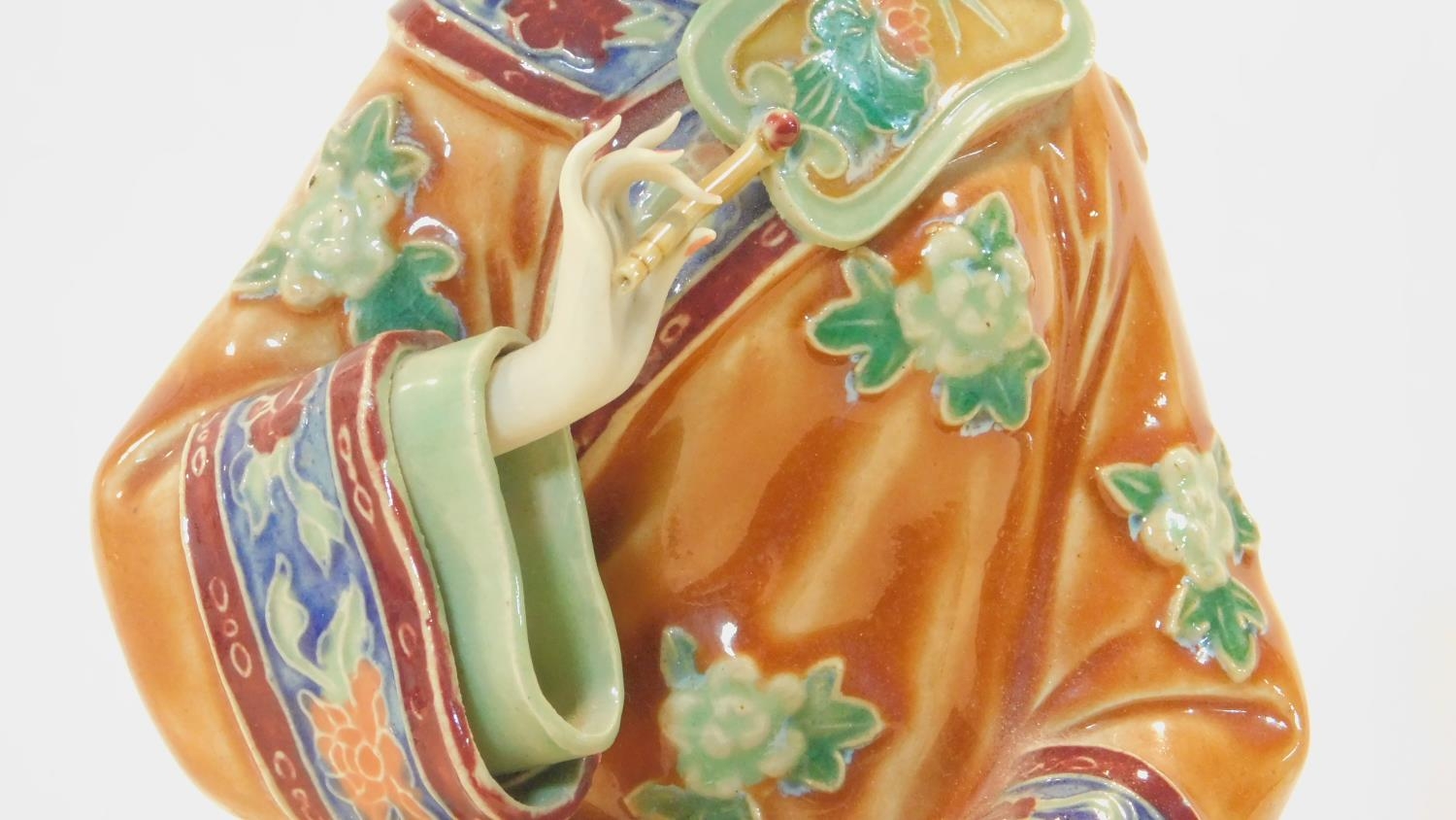 A Japanese ceramic figure of a lady sitting on a garden seat in polychrome hand painted decoration - Image 4 of 8