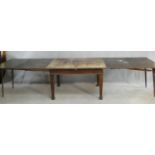 An early 20th century oak extending dining table with central leaf fitted to the underside and