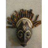 A carved and painted Chokwe Mwano Pwo face mask with tassled headdress, from Angola. 31x18cm