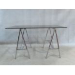 A 1970's vintage side table with smoked plate glass top resting on chrome trestles. H.73 W.128 D.